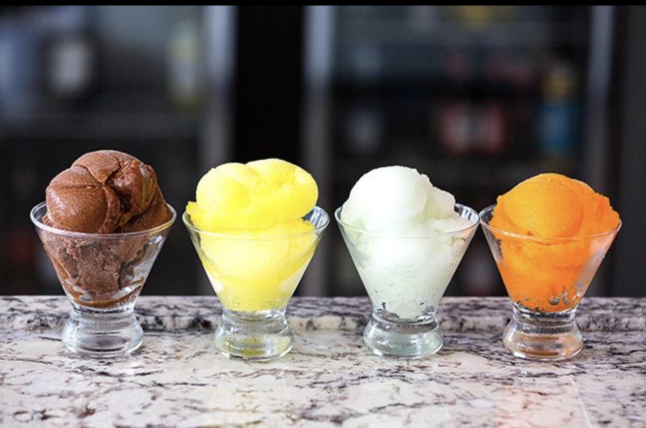 Chocolate, lemon, lime, and orange sorbet scoops served in glass coupes